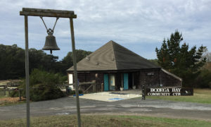 picture of a bell in front of the Bodega Bay Community Center building on a cloudy day